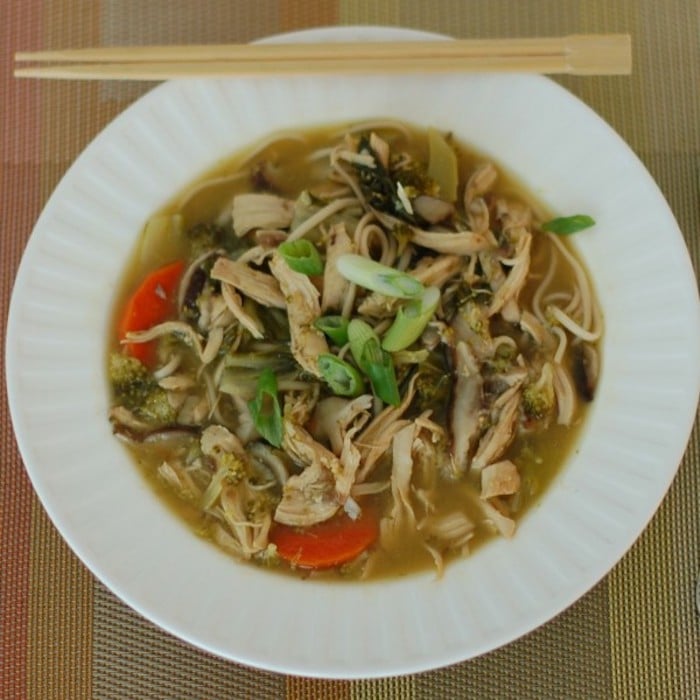 Long noodles signify longevity in Asian countries. Try this Chicken Vegetable Udon Soup to bring in the New Year with this delicious new challenge. Get the dairy-free recipe via JessicaLevinson.com | #udonnoodlesoup #chickesouprecipe #dairyfreesoups Chicken Vegetable Udon Soup in White Bowl