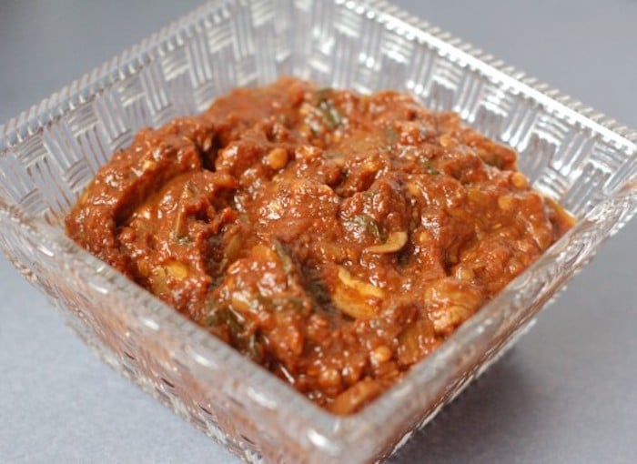 Mushrooms, balsamic vinegar, and tomato paste join together to add a rich, deep umami flavor to this homemade tomato sauce that's lower in sodium than most store-bought varieties. Get the vegan recipe via JessicaLevinson.com #VeganTomatoSauceRecipe #HomemadeTomatoSauceRecipe Easy Homemade Tomato Sauce Recipe in Glass Dish