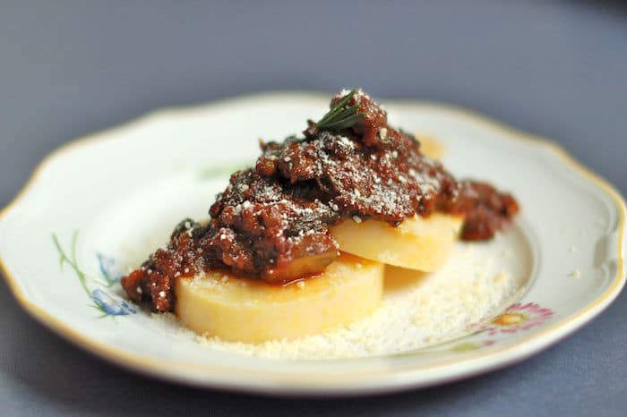 Umami-rich, vegetarian lentil bolognese served over polenta cakes or your favorite pasta is a filling and flavorful dinner meal. vegan bolognese sauce made with lentils