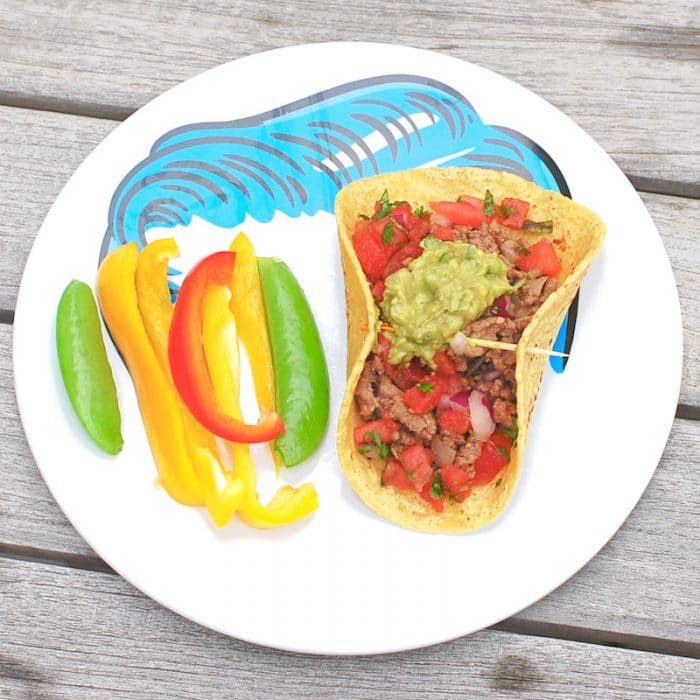 The whole family can participate in taco night with these smoky chipotle beef tacos topped with cooling guacamole and watermelon salsa! Get the gluten-free, dairy-free, and family-friendly recipe @jlevinsonrd. #healthybeeftacos #easybeeftacorecipe Chipotle Beef Tacos on Plate Overhead