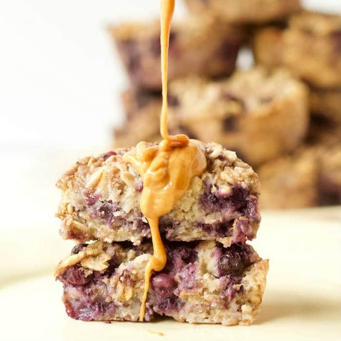 Ricotta Berry Oatmeal Cups | Whole grain oatmeal cups are studded with wild blueberries and full of low-fat dairy and warming spices. A good source of protein, fiber, and calcium, making them the perfect way to start the day! Get the gluten-free, egg-free, vegetarian recipe via JessicaLevinson.com #OatmealCups #EggFreeBreakfast #GlutenFreeOatmeal Ricotta Berry Oatmeal Cups Peanut Butter Drizzle