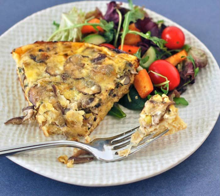 Meaty mushrooms and sweet leeks are a classic combination that pair beautifully in this easy and nutritious frittata that’s perfect for a weeknight dinner or your next weekend brunch. Get the gluten-free and vegetarian recipe via JessicaLevinson.com #GlutenFreeFrittata #VegetarianFrittataRecipe Baked Mushroom Leek Frittata on Plate with Fork