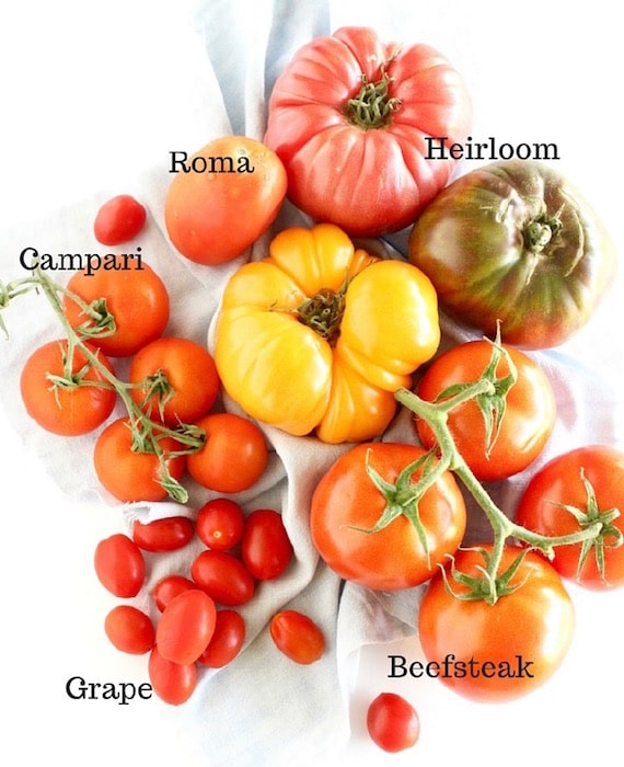 Learn about the varieties, health benefits, & culinary uses of fresh summer tomatoes. Then enjoy delicious & healthy Caprese Couscous Stuffed Tomatoes! Get the quick and easy, vegetarian recipe @jlevinsonrd #capresetomatoes #vegetarianstuffedtomatoes The varieties of summer tomatoes with text overlay