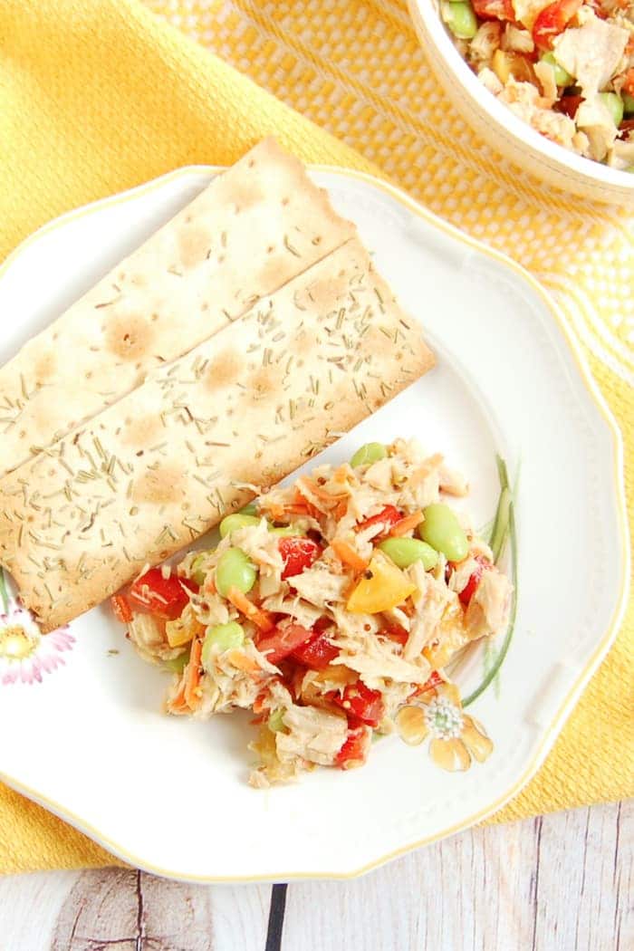 Quick and Easy Tuna Edamame Salad is a healthy, delicious, and balanced lunch the whole family can enjoy. Ready in less than ten minutes, it's perfect for the kids' lunchboxes or over a bed of greens for adults. Recipe via JessicaLevinson.com | #glutenfree #dairyfree #nutfree #eggfree #healthyrecipes #seafood2xWk #tunafish #lunchrecipes #lunchbox Easy Tuna Edamame Salad on Plate with Crackers