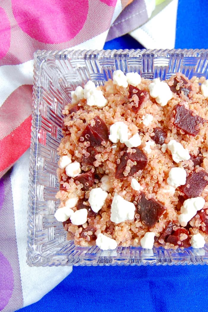Beet and Goat Cheese Quinoa Salad is a simple pairing for a quick and easy lunch. Delicious on its own, over a bed of greens, or as a side dish next to your main course. Get the vegetarian, gluten-free, and nut-free recipe via JessicaLevinson.com #QuinoaSaladRecipe #BeetandGoatCheeseSalad Beet and Goat Cheese Quinoa Salad in Clear Bowl
