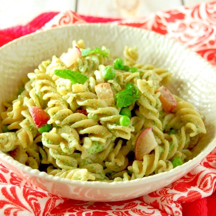 Whole grain pasta is tossed with peas, roasted radishes, and a nut-free mint and radish greens pesto in this light and delicious spring pasta dish. Get this vegetarian recipe via JessicaLevinson.com #SpringPastaSalad #VegetarianPasta #PestoPastaSalad Bowl of Radish Greens Pesto Pasta Salad