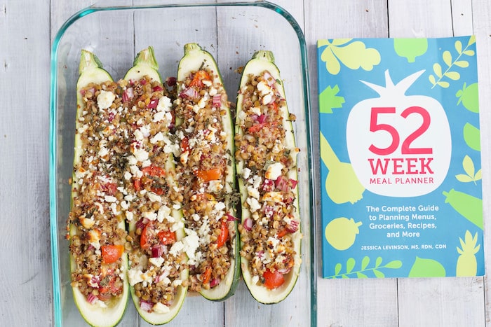 stuffed zucchini boats are a perfect dish for meal planning lentil stuffed zucchini boats in glass baking dish next to meal planner book