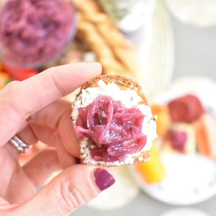 reduced added sugar red onion jam is delicious on top of crackers and cheese red onion jam on cracker with cheese close up